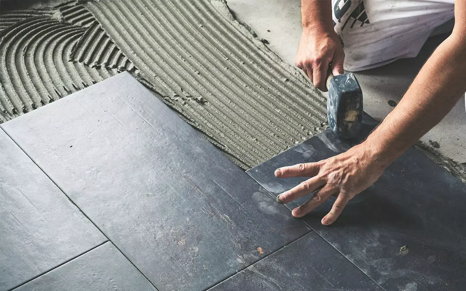 Worker installing tile | Floors In Motion