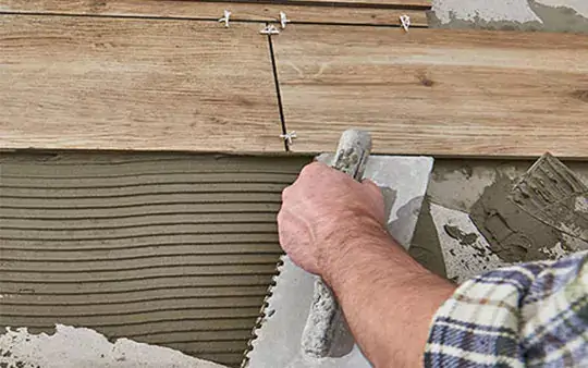 Worker installing tile | Floors In Motion